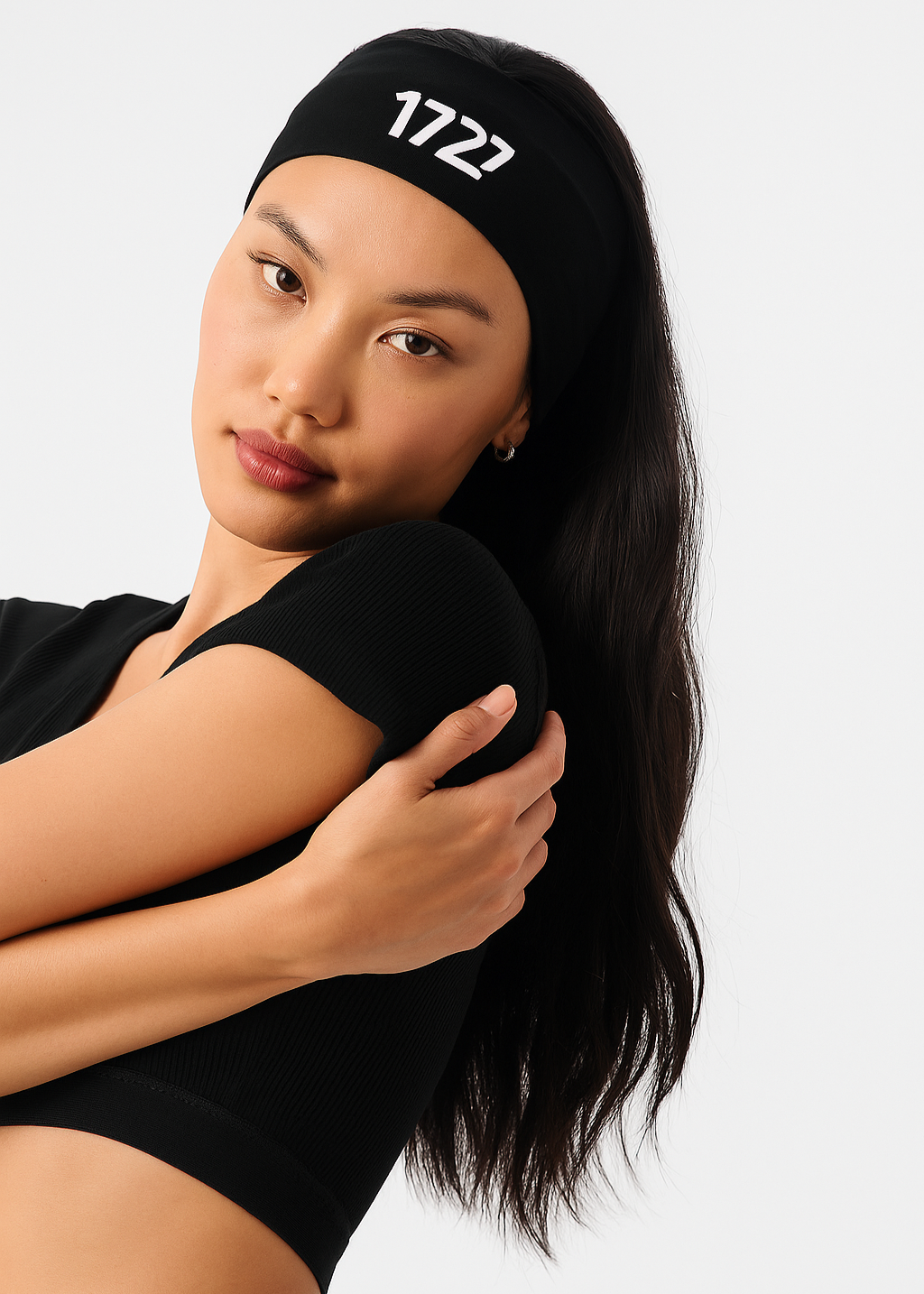 Woman wearing a black headband with '1722' logo on a white background