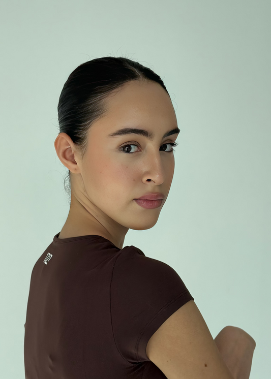 Woman wearing a brown top against a light green background